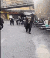 a group of people are walking down a street in front of a building with chinese writing