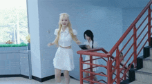 a woman in a white dress is walking down the stairs