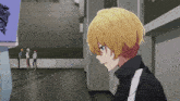 a boy with yellow hair is standing in a hallway with other people