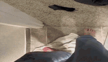 a person 's feet are standing on a towel on a tiled floor