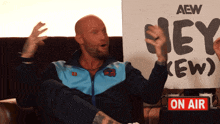 a man holding a sign that says aew on it