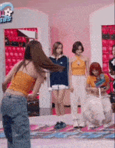 a group of girls are standing on a stage in front of a sign that says ' sds ' on it .