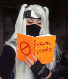 a woman in a naruto costume is reading a book with chinese writing on it .