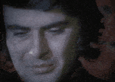 a close up of a man 's face with a dark background
