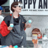 a woman in an apron is standing in front of a sign that says happy an