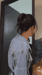 a woman in a denim jacket is standing in front of a mirror with onlyyouseriesth written on the bottom right