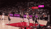 a basketball game is being played in front of a crowd with ads for moda and skyfarm