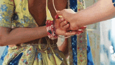 a man and a woman are holding hands in a close up .