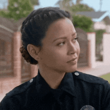 a woman in a police uniform with a braided bun