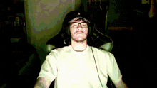 a man wearing glasses and headphones sitting in a chair