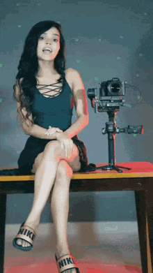 a woman wearing nike sandals sits on a table with a camera