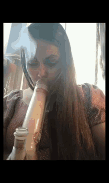 a woman smoking a bong with smoke coming out of her mouth