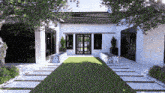 the front of a house with a lush green lawn