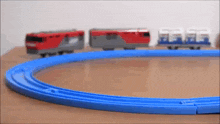 a toy train is going down a blue track on a table .