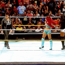 a woman in a tie dye shirt is standing in a boxing ring