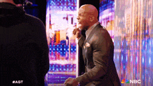 a man in a suit is standing in front of a screen that says nbc