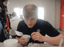 a boy in a black shirt is eating ice cream with a fork