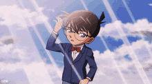 a boy in a suit and bow tie is standing in front of a cloudy sky