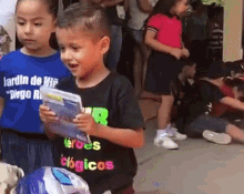 a boy and a girl are standing next to each other and the boy is wearing a shirt that says " heroes clásicos "