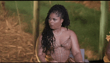 a woman with dreadlocks is sitting in a chair with a microphone in her hand .