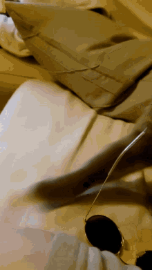 a person is laying on a bed with a pair of sunglasses on their lap