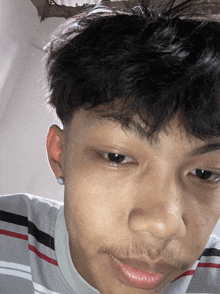 a close up of a man 's face with a striped shirt
