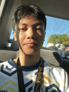 a young man sitting in a car with a lanyard that says ' u.s.a. ' on it