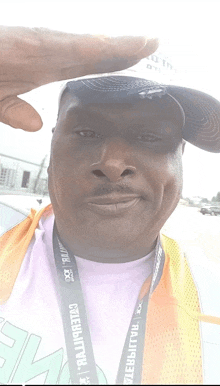 a man wearing an orange vest and a lanyard that says ' celebration ' on it