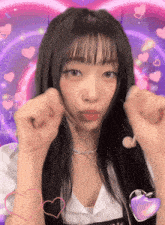 a girl with long black hair making a heart with her hands
