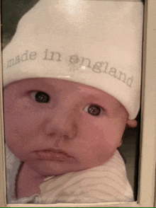 a baby wearing a hat that says made in england on it
