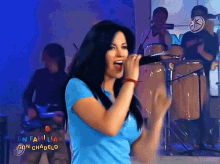 a woman singing in front of a band that says en familia on the bottom right