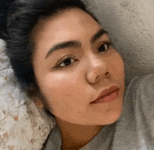 a close up of a woman 's face while laying on a pillow .