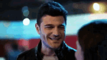 a man is smiling and looking at a woman .