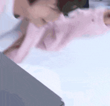 a blurred image of a person laying on a bed with a laptop