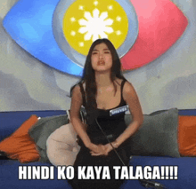a woman sitting in front of a big eye with the words hindi ko kaya talaga !!! written below her