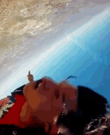 a person in a red shirt is laying in a swimming pool