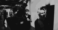 a black and white photo of a group of people standing in a room .