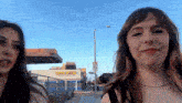 two women are standing in front of a building that says ' ferris wheel ' on it