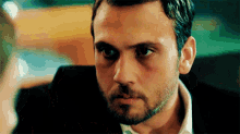 a close up of a man with a beard looking at something