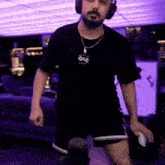 a man with a beard wearing headphones and a necklace with a pendant that says ' sds '