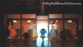 a man in a blue scrub suit is jumping in the air while a group of people watch