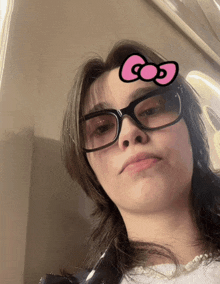 a woman wearing glasses has a pink bow on her face