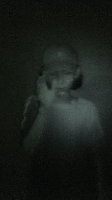 a blurry picture of a person with glasses and a baseball cap