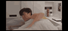 a man is laying on a bed with a clock on the wall behind him