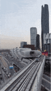 a train is going down the tracks in front of a building with a sign that says ' a ' on it