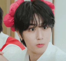 a close up of a person with a red flower in their hair