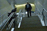 a man walking up a set of stairs with a briefcase in his hand