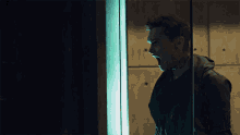 a man with a tattoo on his arm is screaming behind a glass door