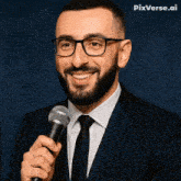 a man in a suit and tie is smiling while holding a microphone with pixverse.ai in the background