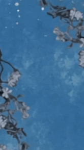 snow is falling on a tree branch with flowers in the foreground